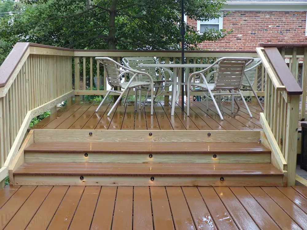 Hybrid deck with stairs leading to raised area with outdoor dining furniture