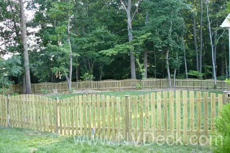 Pine Fencing around a backyard with woods outside yard